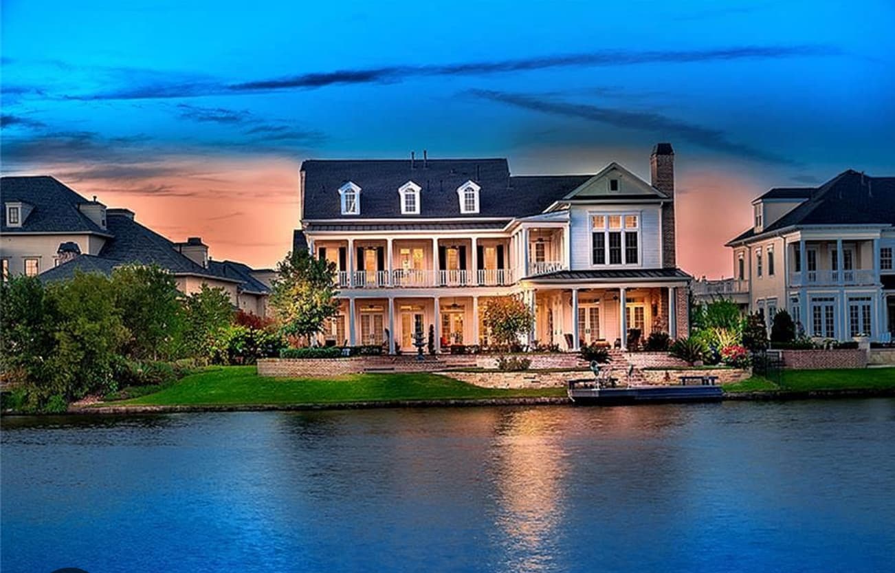 Grand multi-story house on the edge of a calm body of water