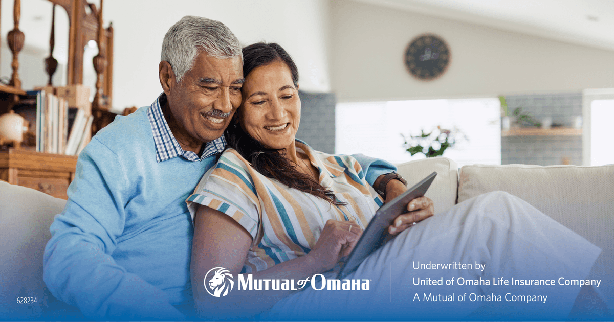 Older couple on sofa with tablet - Mutual of Omaha final expense insurance